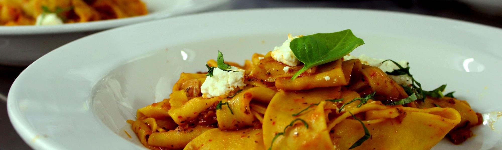 Fresh made pappardelle with basil, tomato and goat cheese